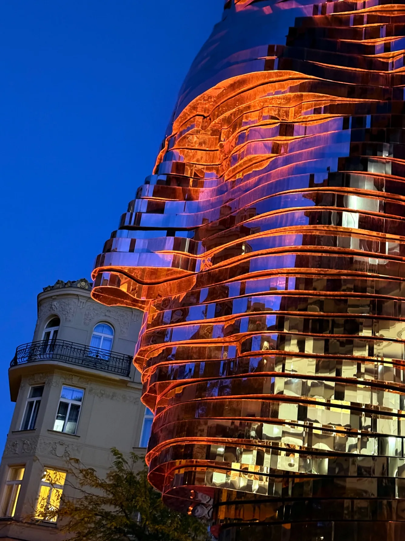 Kinetic Head of Franz Kafka sculpture glowing blue at night in Prague
