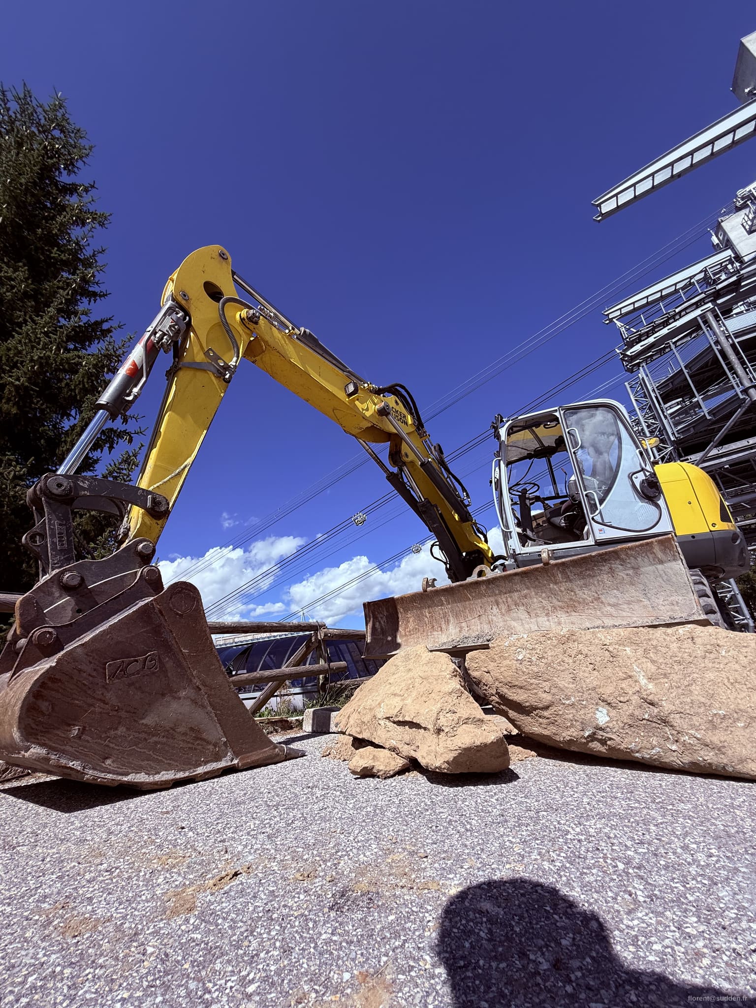 Gros plan sur le godet d'une pelleteuse sur le chantier de Peisey-Vallandry, ciel bleu en arrière-plan